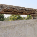 An example of concrete corrosion, showing the top of an outdoor structure with badly damaged concrete surface.