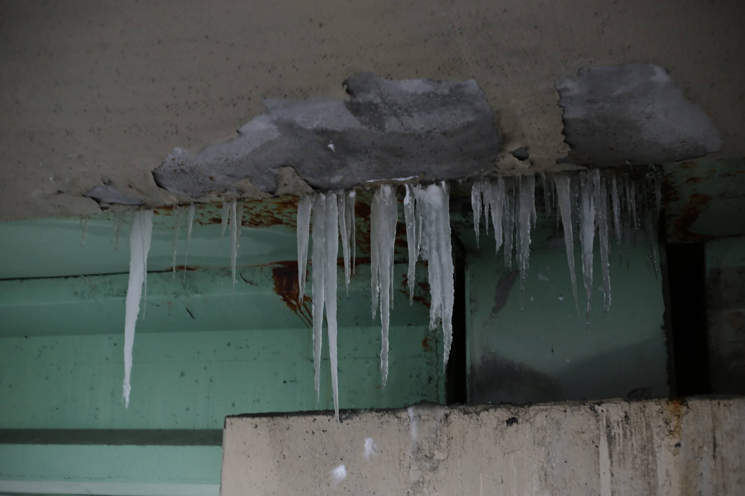 Ice forming along a concrete joint as an example of freeze-thaw damage.